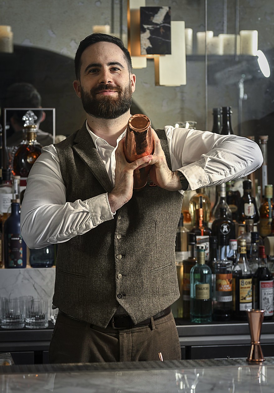 Alexis Desbruères derrière le bar, préparant un cocktail
